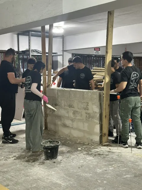Estudiantes levantando una pared de bloques.