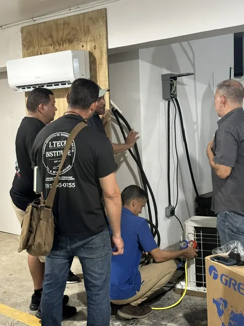 Estudiantes instalando la unidad interior de un mini split.